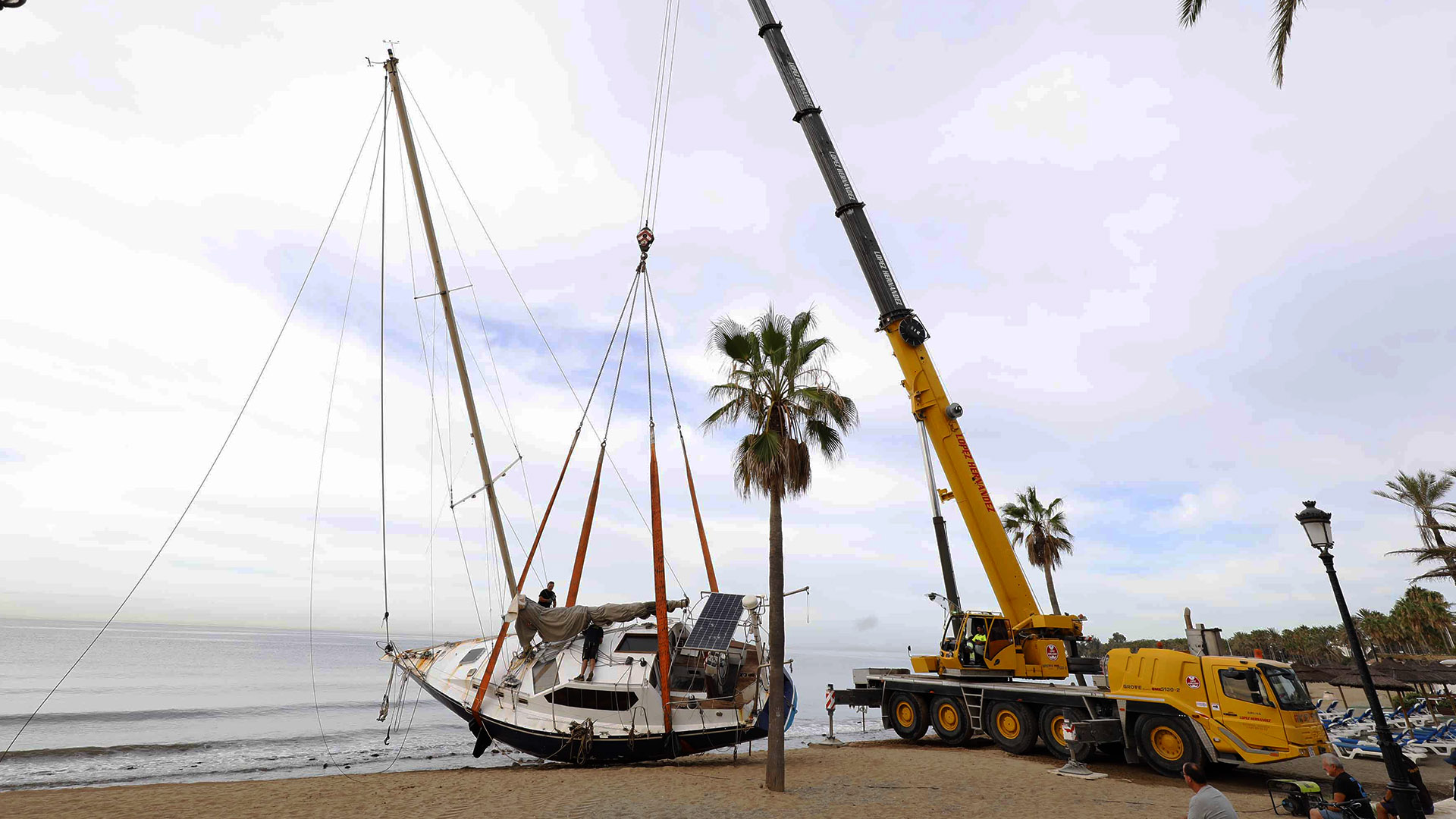 Retirado con una gran grúa el velero encallado en la playa de Cortijo Blanco